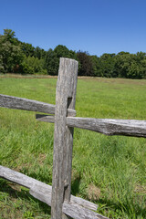 beautiful countryside scene with green fields, trees, blue sky, and a rustic wooden fence