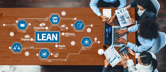 A diverse team engages in collaborative efforts to enhance lean management strategies, using technology and data visualization tools in a modern office environment. Amity
