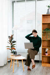 Beautiful Asian woman working in a coffee shop. Portrait of a freelancer working in a coffee shop using a laptop and notebook. Young woman's weekend hobby.