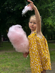 Girl in yellow dress eating cotton candy