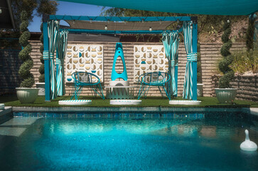 Daytime view over a long, sparkling blue pool in a desert oasis yard, featuring a stylish lounge...