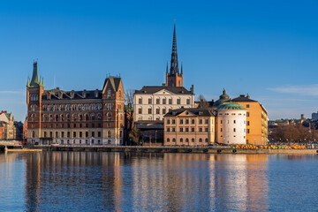 Obraz premium Historic buildings and Riddarholmen Church reflecting in Stockholm waters