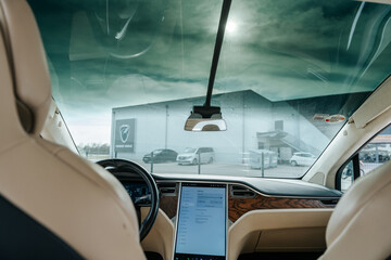Luxury modern car interior with sleek black and white design, steering wheel, gauges, and...