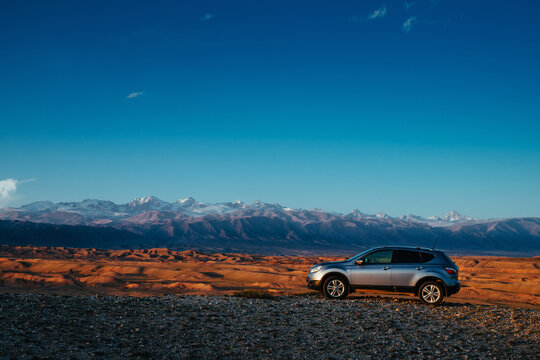 Kyrgyzstan - April 08, 2025: Nissan Qashqai car standing on high mountains background in twilight