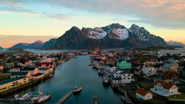 Henningsv&aelig;r auf den Lofoten in Norwegen bei Sonnenaufgang, klare und kalte Luft &uuml;ber der Inselgruppe mit Fischerh&auml;usern, Meer und felsiger K&uuml;stenlandschaft im weichen arktischen Morgenlicht