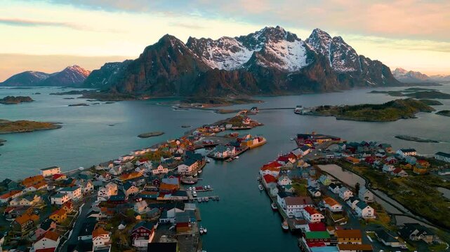 Henningsv&aelig;r auf den Lofoten in Norwegen bei Sonnenaufgang, klare und kalte Luft &uuml;ber der Inselgruppe mit Fischerh&auml;usern, Meer und felsiger K&uuml;stenlandschaft im weichen arktischen Morgenlicht
