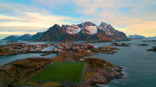 Henningsv&aelig;r auf den Lofoten in Norwegen bei Sonnenaufgang, klare und kalte Luft &uuml;ber der Inselgruppe mit Fischerh&auml;usern, Meer und felsiger K&uuml;stenlandschaft im weichen arktischen Morgenlicht