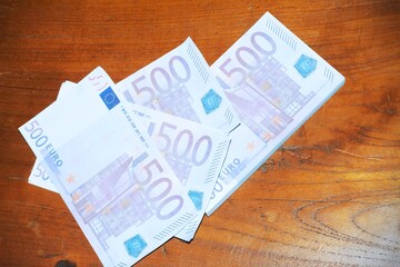 500 euros banknotes on a wooden background.