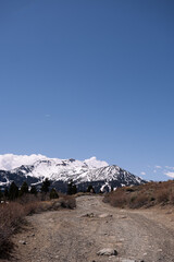 Pristine snow-capped mountain crest set against an uninterrupted deep blue sky, embodying minimalist alpine beauty and the exhilarating clarity of high-altitude winter landscapes
