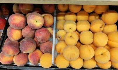 Two bins of peaches, one with red and one with yellow