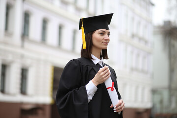 A happy graduate in cap and gown smiles and celebrates, the concept of education