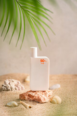 Sunblock or sunscreen in cosmetic tube on beach sand and beige background. Summer vacation and skin care concept with starfish and sea shells, spf uv-protect cosmetics. Skin health. High quality photo