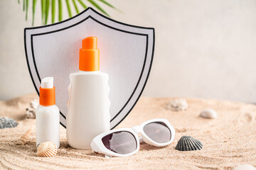 Sunblock or sunscreen in cosmetic tube against a shield as a symbol of sun protection on beach sand background. Summer vacation and skin care concept, spf uv-protect cosmetics. Skin health.