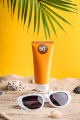 Sunblock or sunscreen in cosmetic tube on beach sand and beige background. Summer vacation and skin care concept with starfish and sea shells, spf uv-protect cosmetics. Skin health. High quality photo