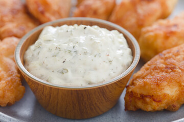 Fresh homemade tartar sauce made of mayonnaise, pickles, capers, herbs, salt and pepper, with fried...