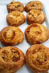 Close-up of a variety of pastry rolls, styled on a tray at a bakery.