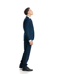 side view of curious young businessman looking up while walking