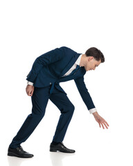 side view of handsome young businessman bending and grabbing