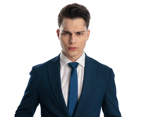 upset young businessman in navy blue suit making an angry face and frowning