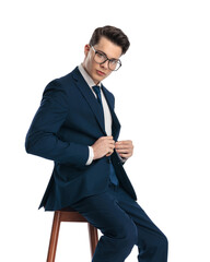 confident young businessman with glasses closing navy blue suit