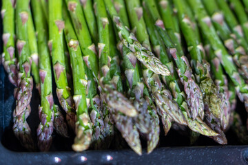 A tight macro capture of fresh green asparagus spears, highlighting their vivid color and natural...