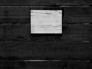 house number  on brown varnished wooden fence. empty blank White plate plank. Cracked dried paint.