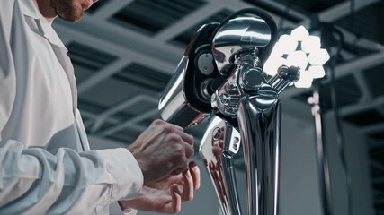 Engineer performs precision maintenance on advanced equipment in a clean workshop during daytime hours