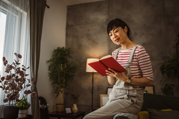 one female mature japanese woman read book at home