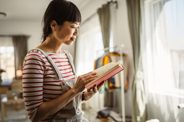 one female mature japanese woman read book at home