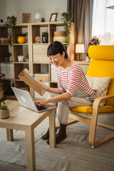 one japanese woman checking box of received package or product at home