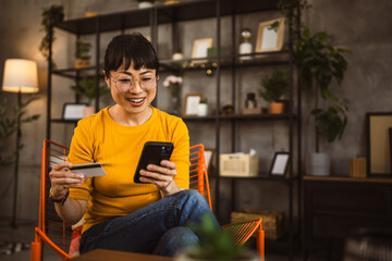 Japanese woman use credit card mobile phone online shopping at home