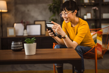 Japanese woman use credit card mobile phone online shopping at home