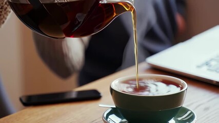 Pouring fresh coffee into cup with gentle steam and cozy morning vibes