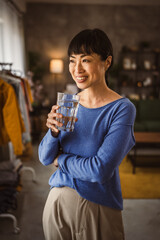 portrait of one japanese mature woman with glass of water at home