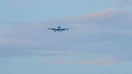 Distant view of a passenger jet with no visible airline branding on final approach for landing.