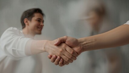 Two people shaking hands with abstract and blurry background,Focus on the handshake movement,gesture,team,deal