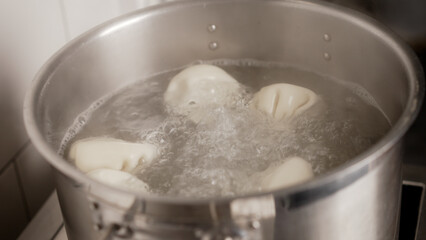 Khinkali boiling in metal pot: traditional georgian dumplings cooking