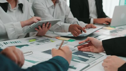 Diverse professionals engage in teamwork, analyzing data using digital devices and charts. A modern office setting fosters collaboration and strategic discussion for better outcomes. SACTR - Powered by Adobe