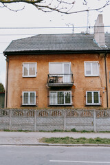 old brown building with a balcony. The building is surrounded by a fence. walking in the old town, traveling to tourist places.