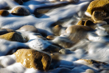 Flowing ocean water over stones evokes a meditative and peaceful state of mind