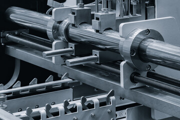 Machine with a long metal rod on it. The rod is being held in place by a metal piece