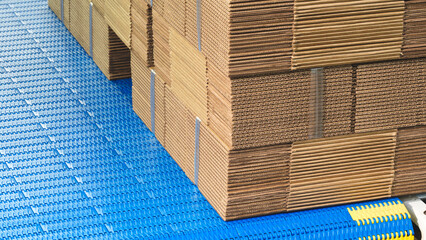 Elements of corton boxes are collected in stack. Conveyor line for the production of boxes. Machine...