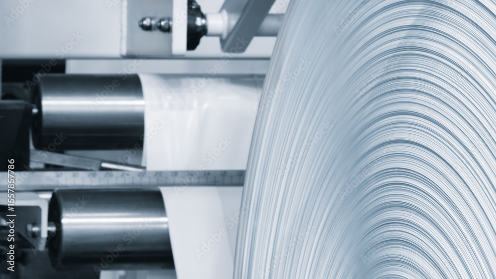 Poster Machine with roll of paper on it. Machine is in factory. industrial food packaging concept background