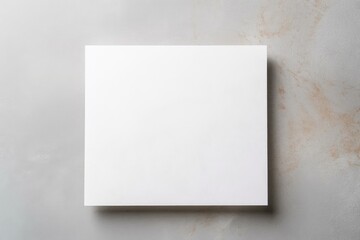 Empty white paper sheet resting on gray marble background providing copy space for text or artwork