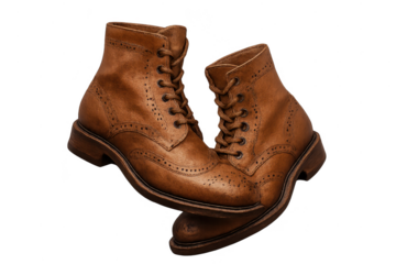 A stylish pair of brown leather brogue boots isolated on transparent background, fashion.