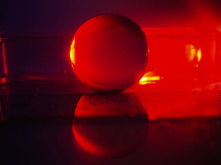 A clear glass ball is sitting on a pedestal. Colorful background. Abstract graphic background....