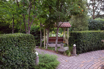 A beautiful European garden with green fences, lawns, trees, bushes.