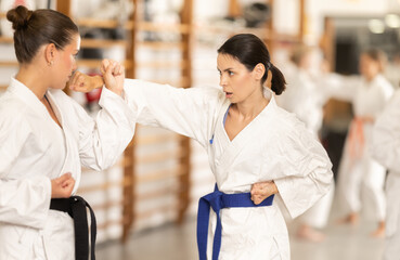 Young female partners pupils are trained to perform defensive karate installations sparring with...