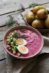 Rustic Presentation of Cold Beet Soup with Cucumber, Egg, and Dill, Served with New Potatoes on a Wooden Table