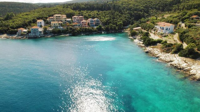 Colorful coastal houses by forest and blue bay in Fiskardo Kefalonia Greece